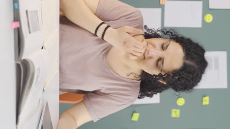 Vertical-video-of-Female-student-stressed-and-biting-her-nails.